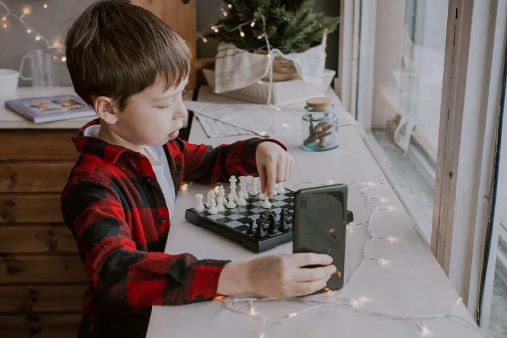 a boy learning to play chess online