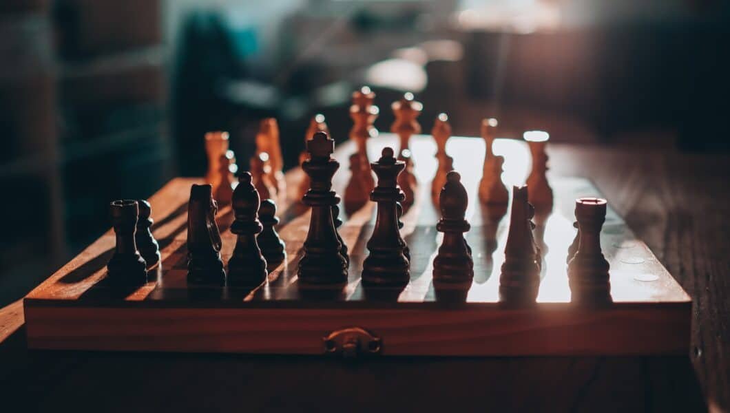 wooden chess board with pieces in the starting position