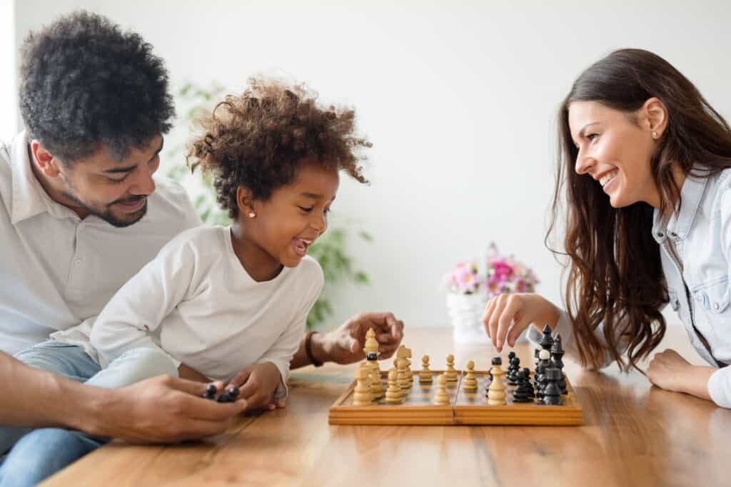 Happy family playing chess together