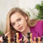 young girl with blond hair playing chess